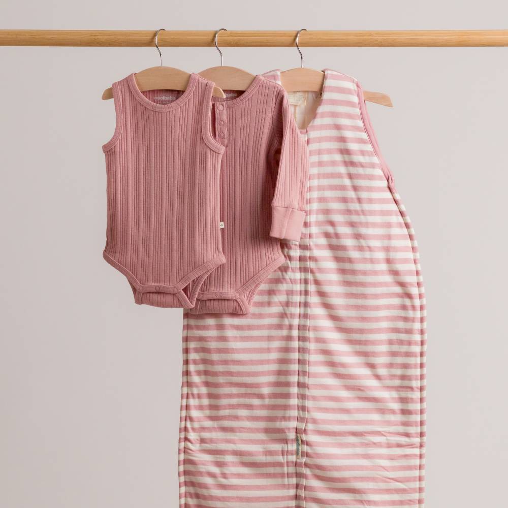 Dusk pink woolbabe collection hanging on a rail