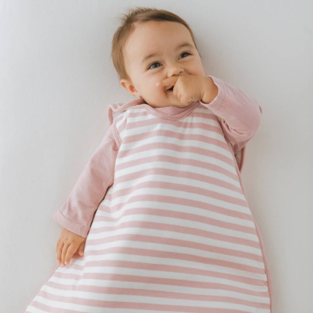 Baby wearing a pink and white striped outfit against a plain background