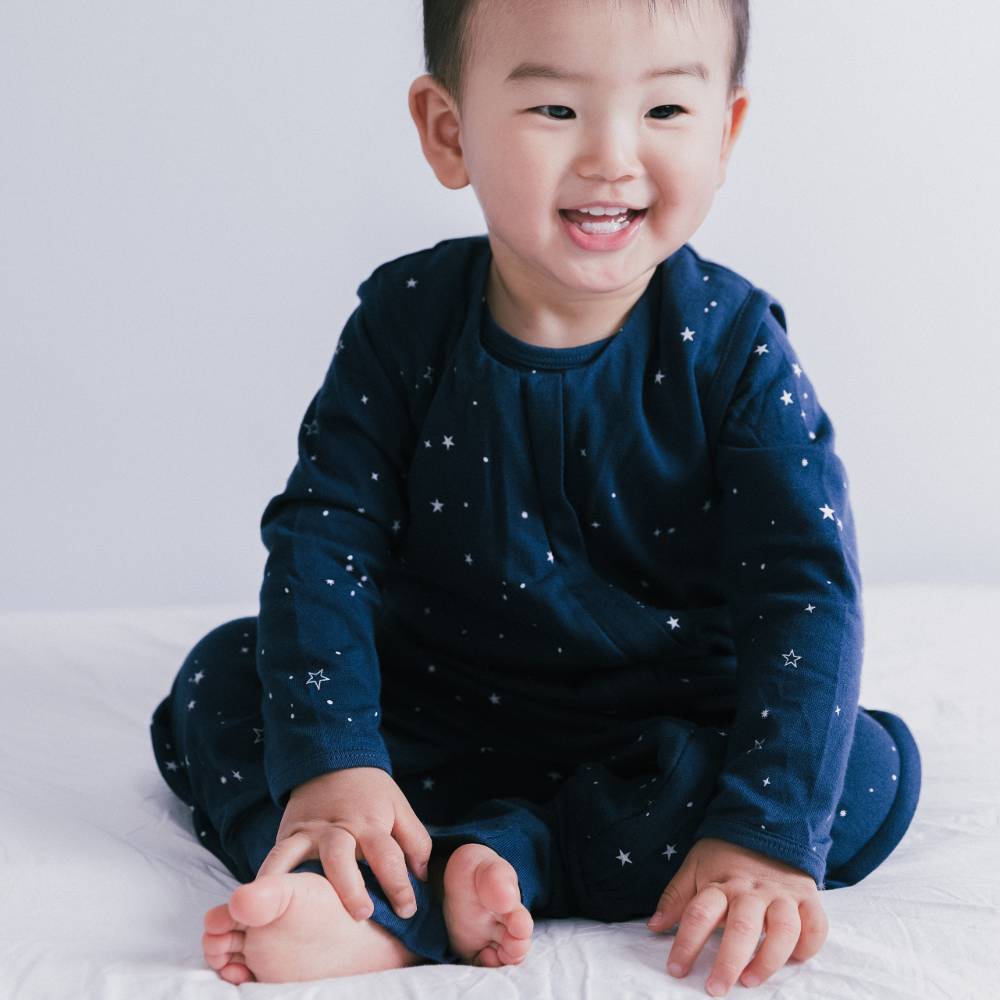Child wearing a navy blue outfit with star patterns on a white background
