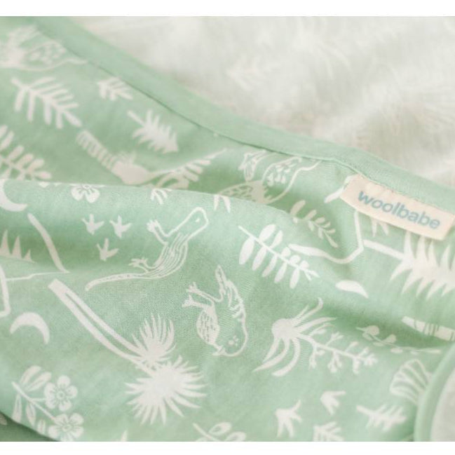 Green fabric with white New Zealand Aotearoa animal prints and 'woolbabe' branding on a white background