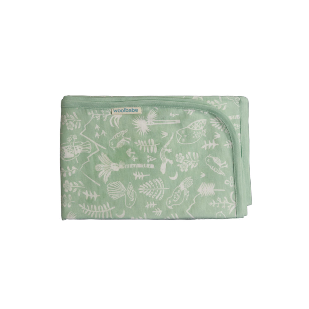 Green baby merino cotton swaddling blanket with white floral pattern on a white background