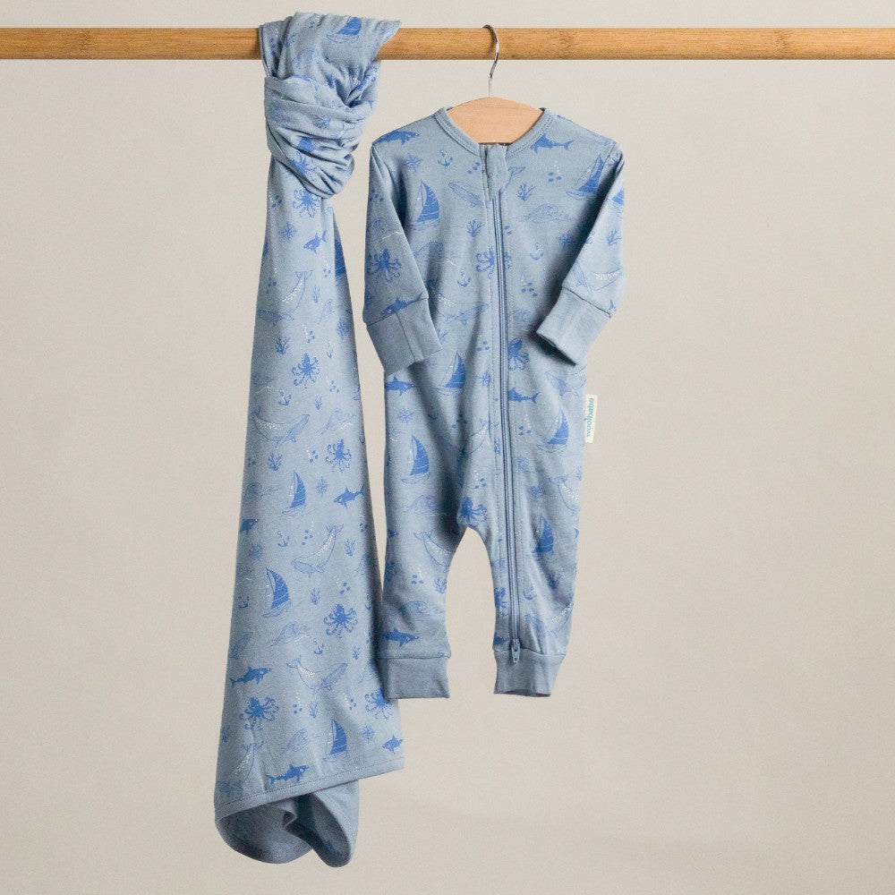 Blue baby onesie with animal print on a beige background