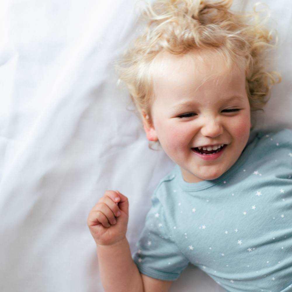 Child wearing a light blue shirt with star patterns on a white background