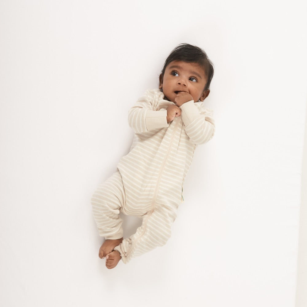Baby wearing a white ribbed onesie on a white background