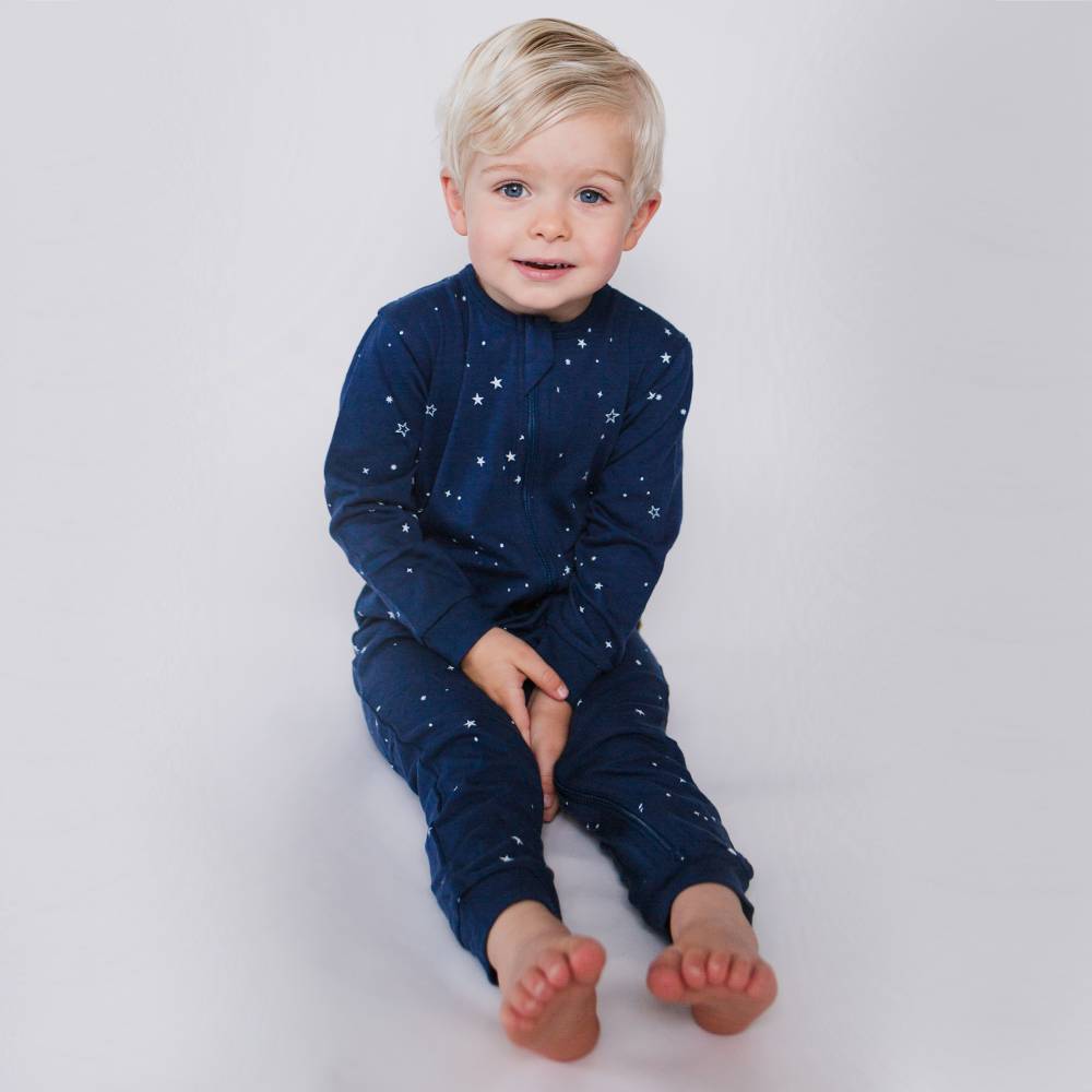 Child wearing a navy blue outfit with star patterns on a white background