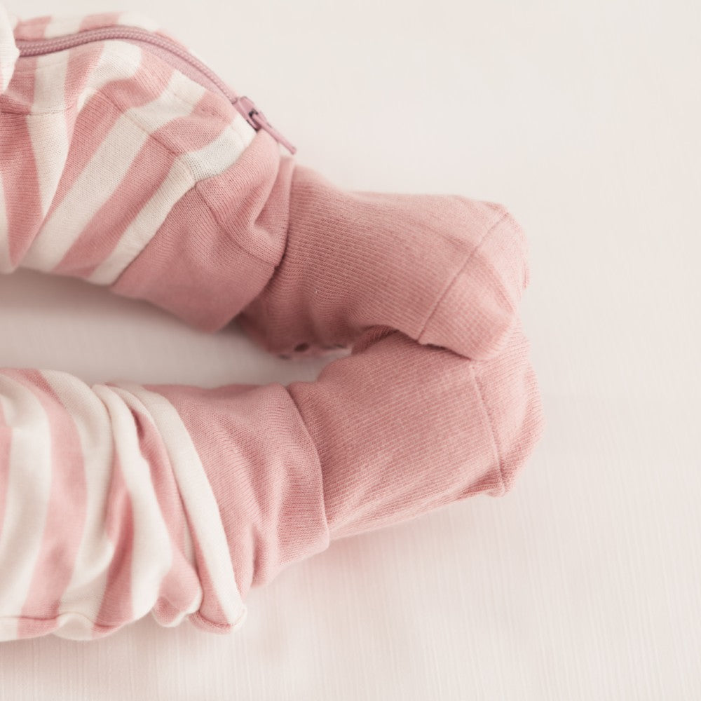 Pink and white striped baby outfit on a light pink background
