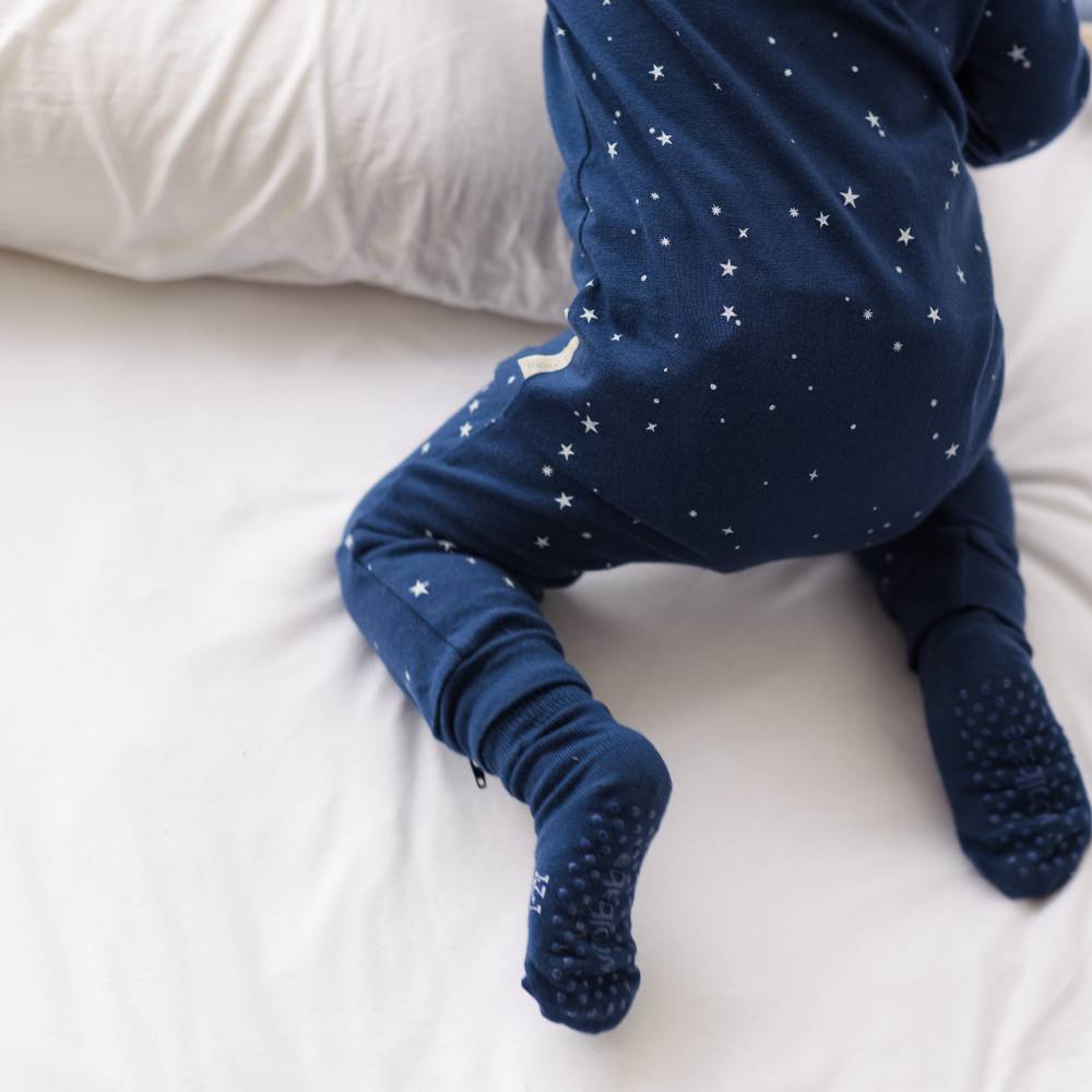 Navy blue baby onesie with star pattern on a white surface