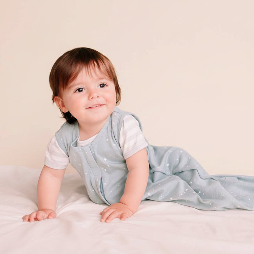Baby in a light blue outfit with white polka dots on a dark blue background
