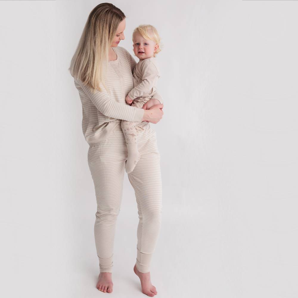beige mum and baby wearing woolbabe relax pants, henley top and PJ suit