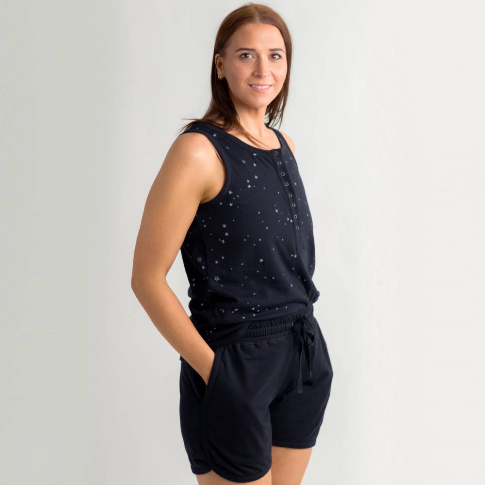 Woman wearing a black sleeveless top and shorts set on a light gray background