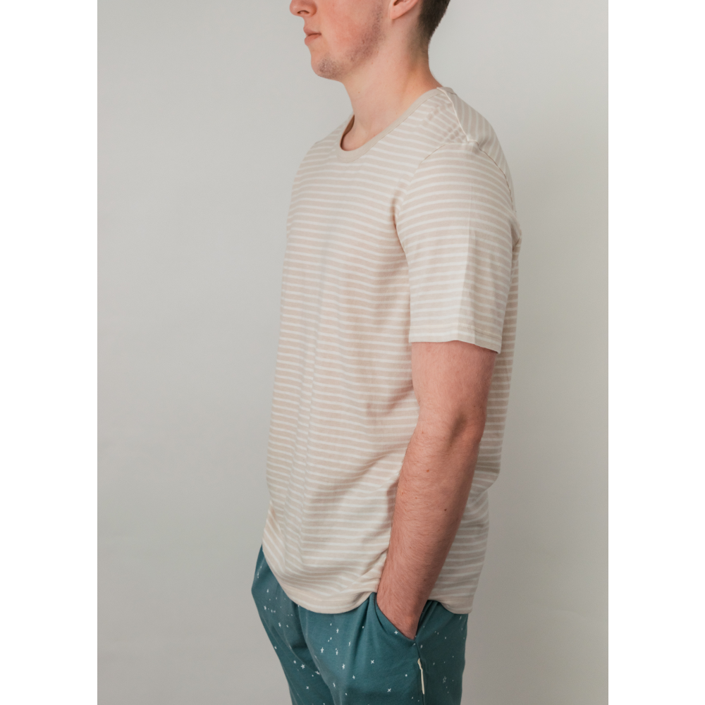 Person wearing a striped shirt and green pants against a plain background