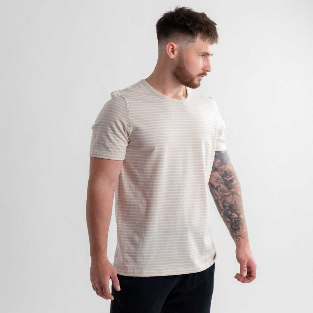 woolbabe beige dune stipe adult tshirt worn on a man with tattoos and black pants