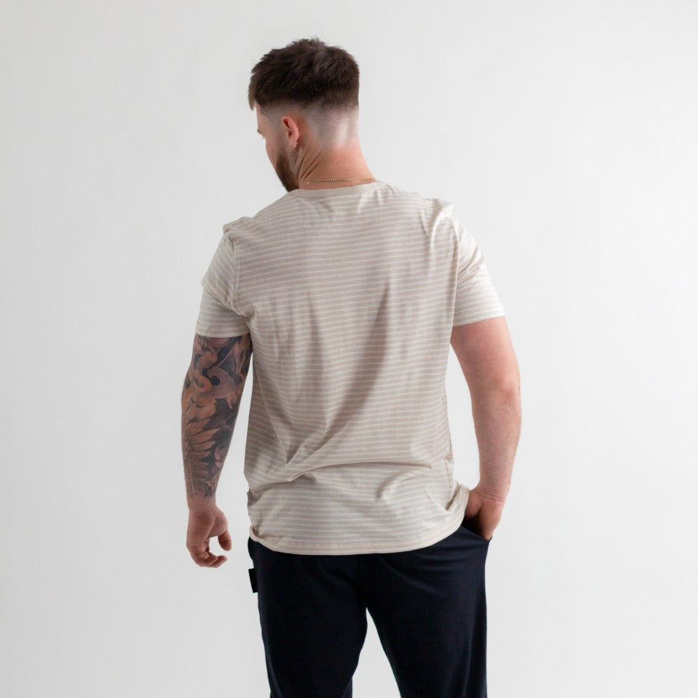 woolbabe beige dune stipe adult tshirt worn on a man with tattoos and black pants