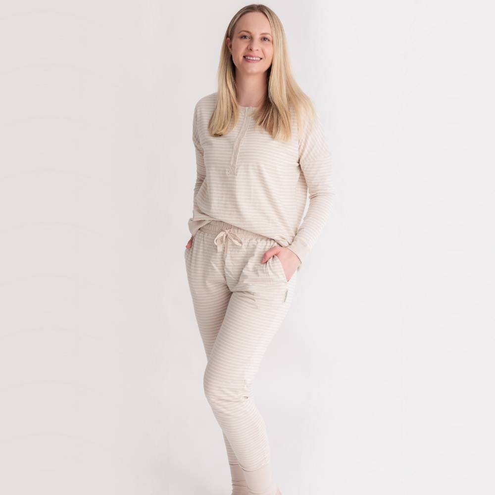 Woman wearing a beige striped pajama set on a white background
