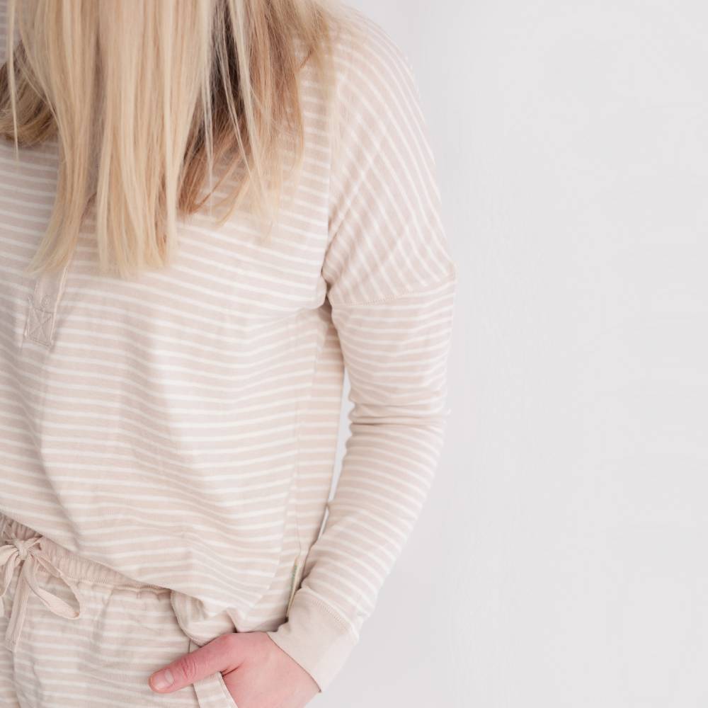 Person wearing a beige ribbed long-sleeve top and matching pants on a light background
