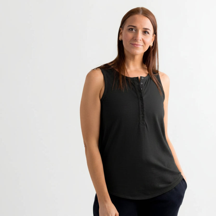 Woman wearing a black sleeveless top with star patterns on a white background