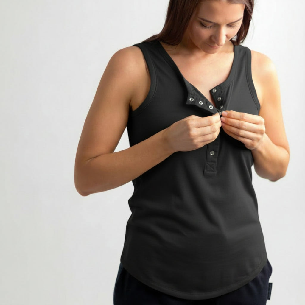 Woman wearing a black sleeveless top with star pattern on a plain background
