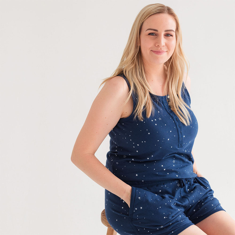 Woman wearing a navy blue outfit with star patterns on a white background