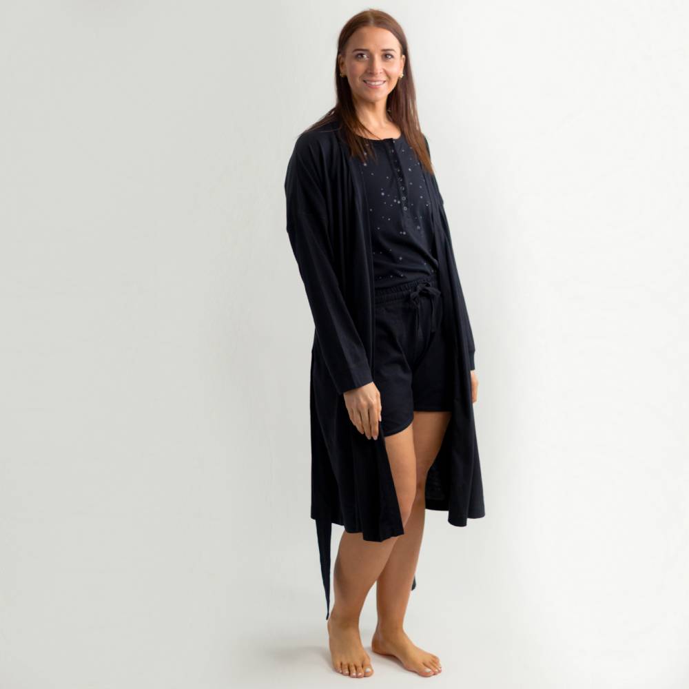 Woman wearing a black loungewear set on a white background