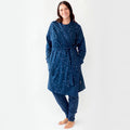 Woman wearing a blue star-patterned merino robe and pants on a white background