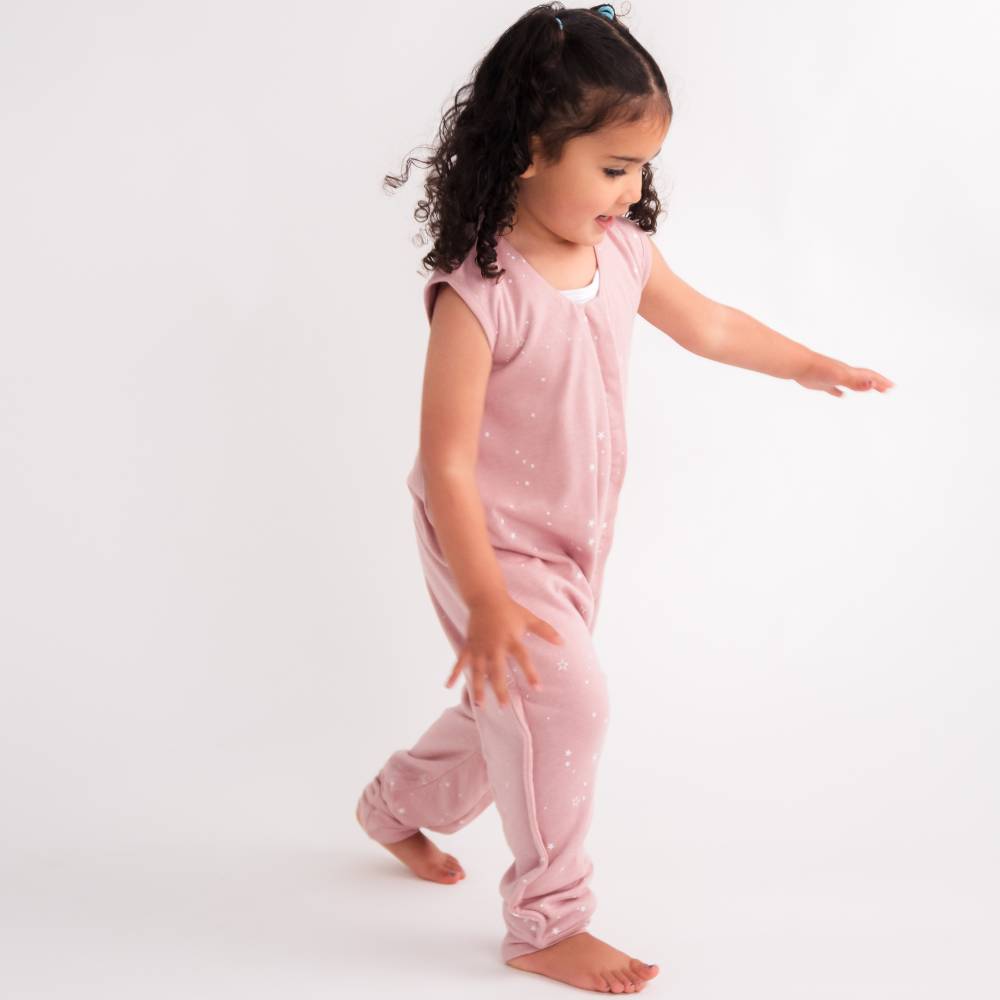 Child wearing a pink onesie on a white background