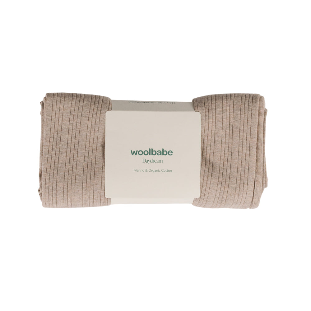 Folded baby blanket with 'woolbabe' branding on a white background
