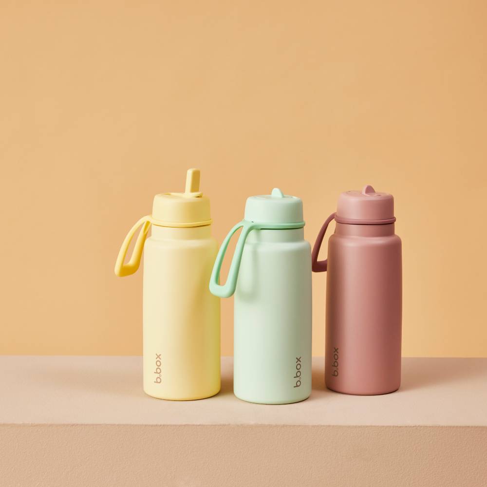 Three colorful water bottles with 'bbox' branding on a beige background