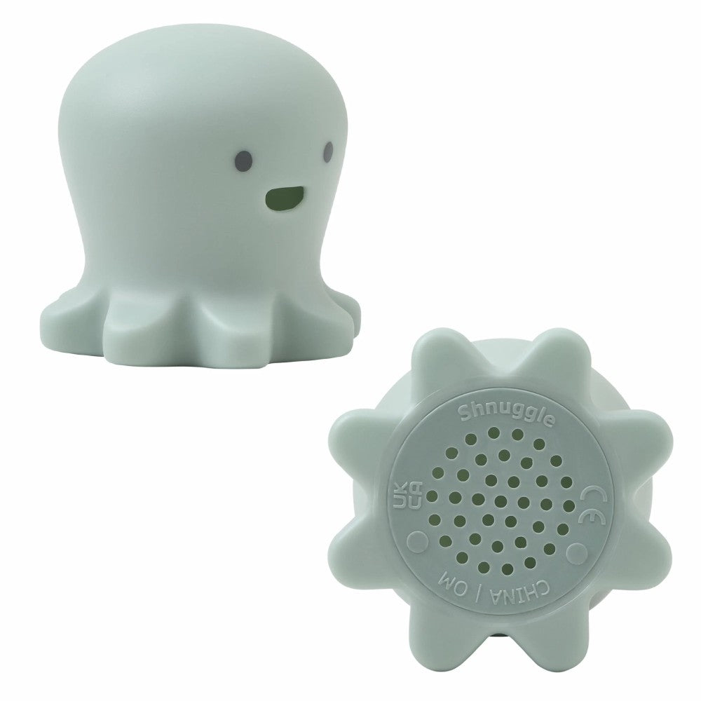 A pale mint green silicone bath toy shaped like a smiling octopus, shown from the front and back on a plain white background. The back features a star-shaped base with a circular grid of small holes and the brand name 'Shnuggle' embossed in the center.