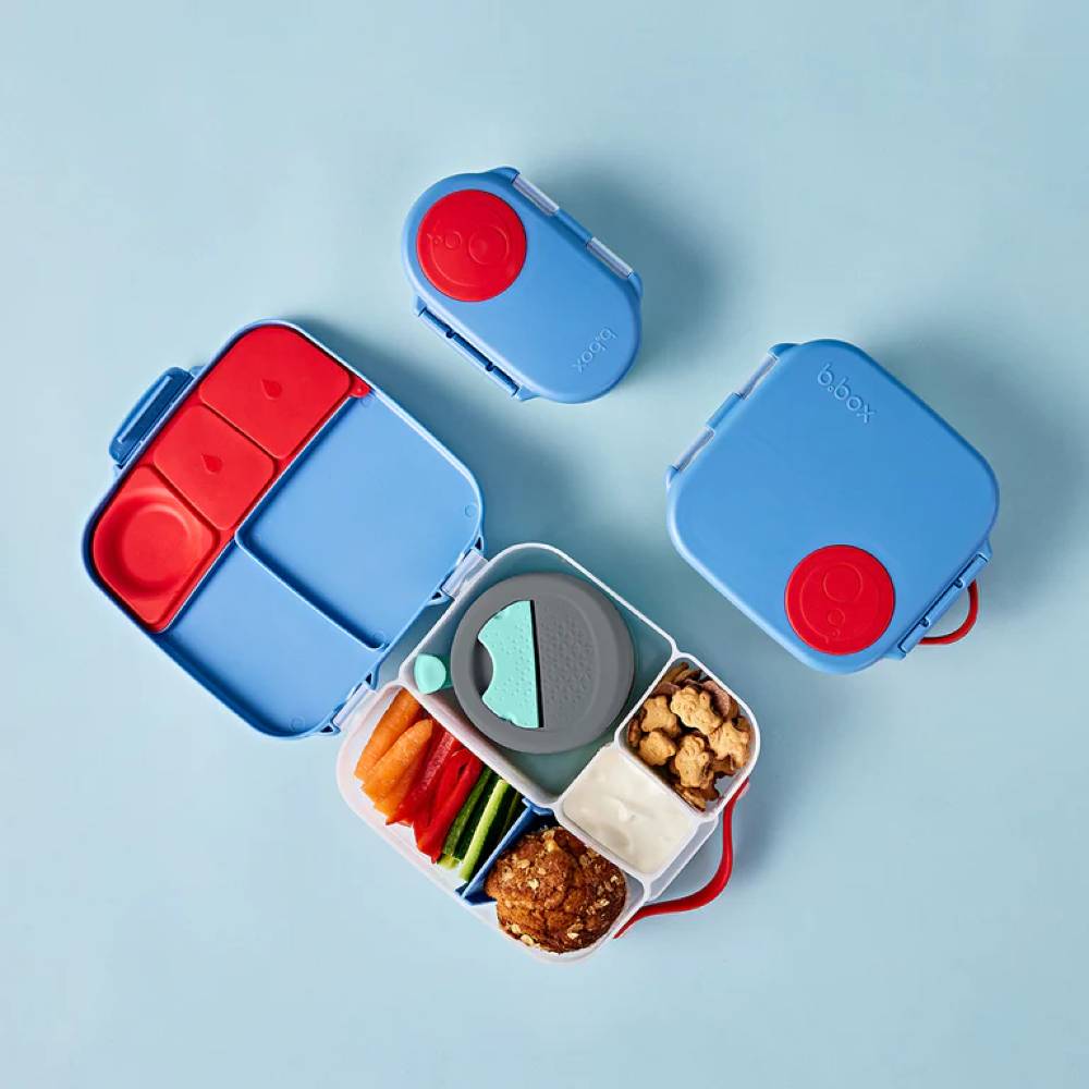 Blue and red bento box with compartments on a light blue background