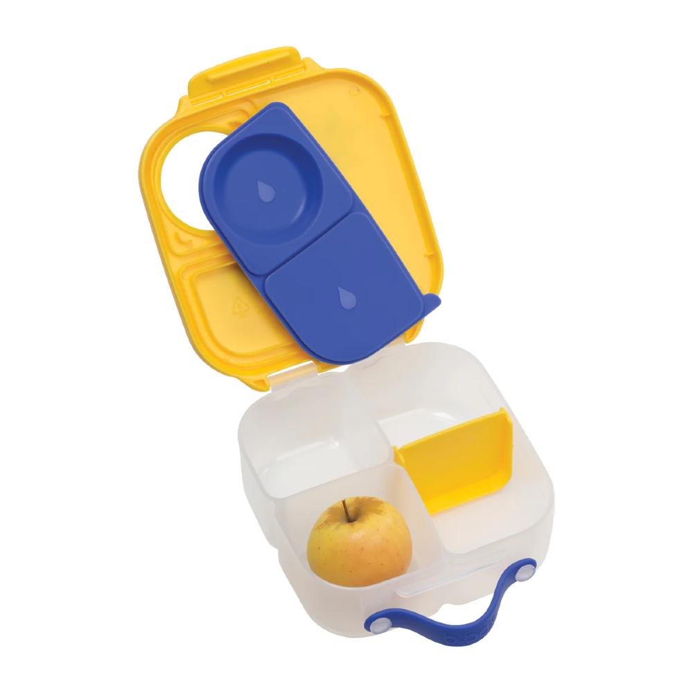 Yellow and blue lunchbox with a white interior holding an apple on a white background