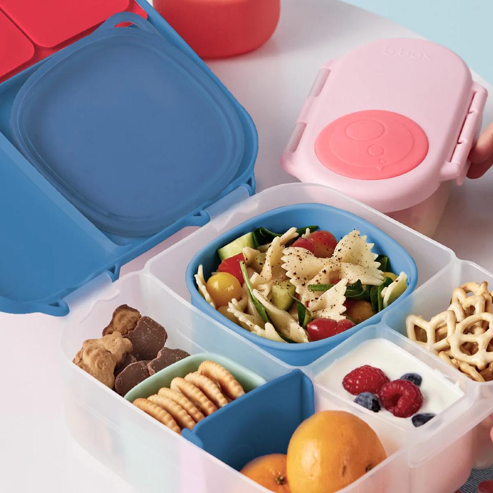 Colorful bento box with compartments containing food items on a white background