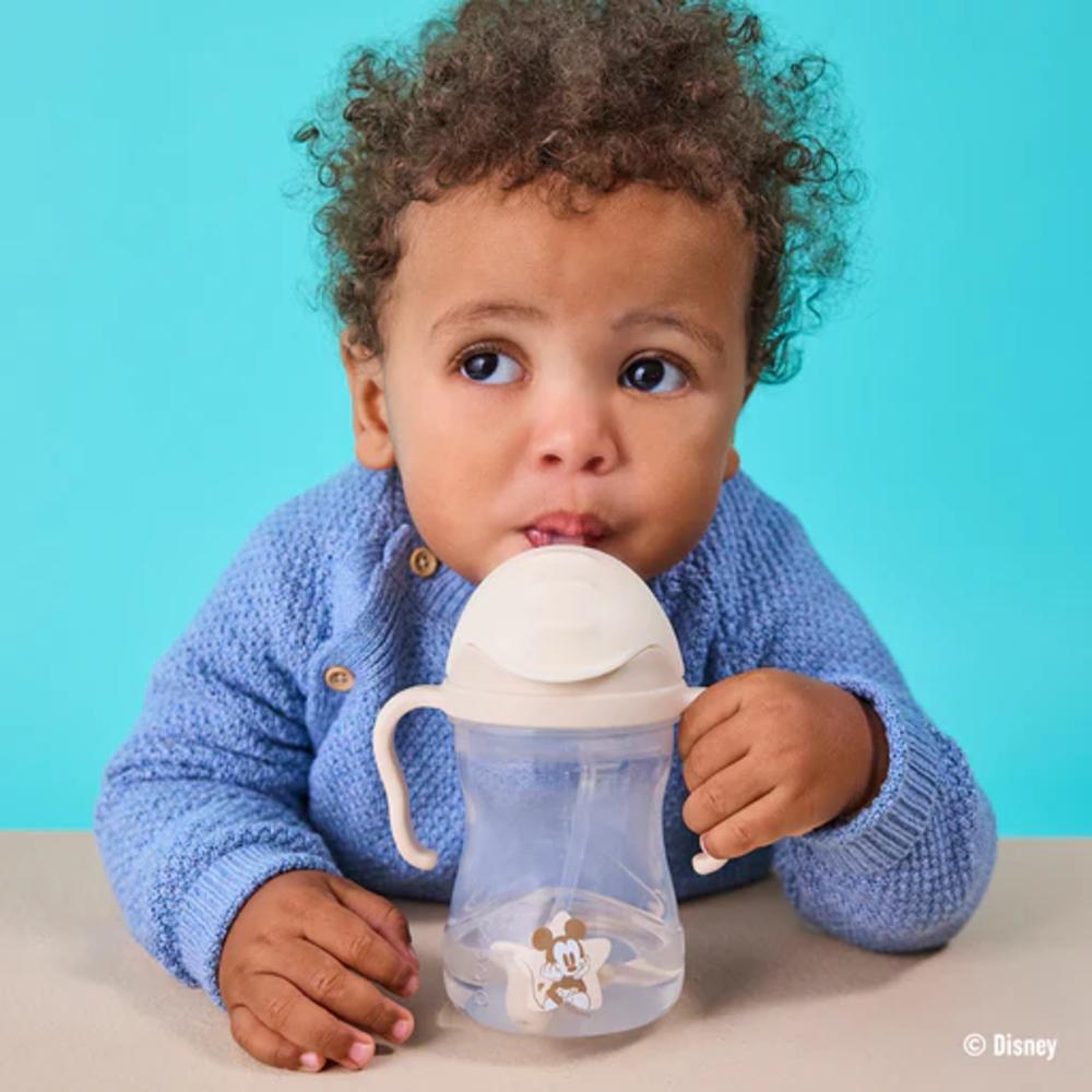 Child drinking from a sippy cup with a blue background