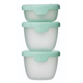 Three stacked food containers with green lids on a white background