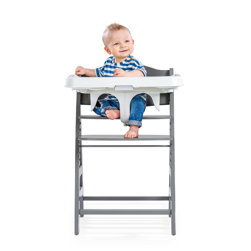 Child sitting on a Hauck high chair with a white background