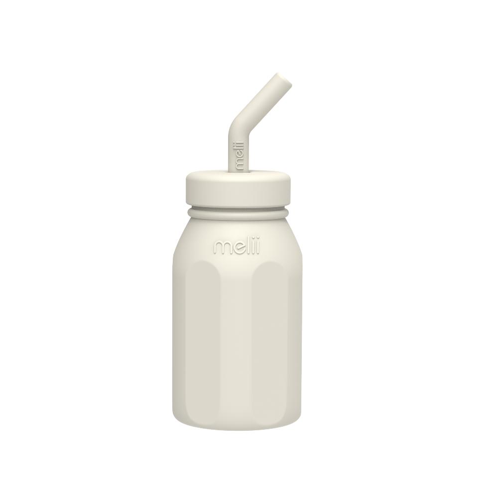 Cream silicone bottle with straw lid on a white background