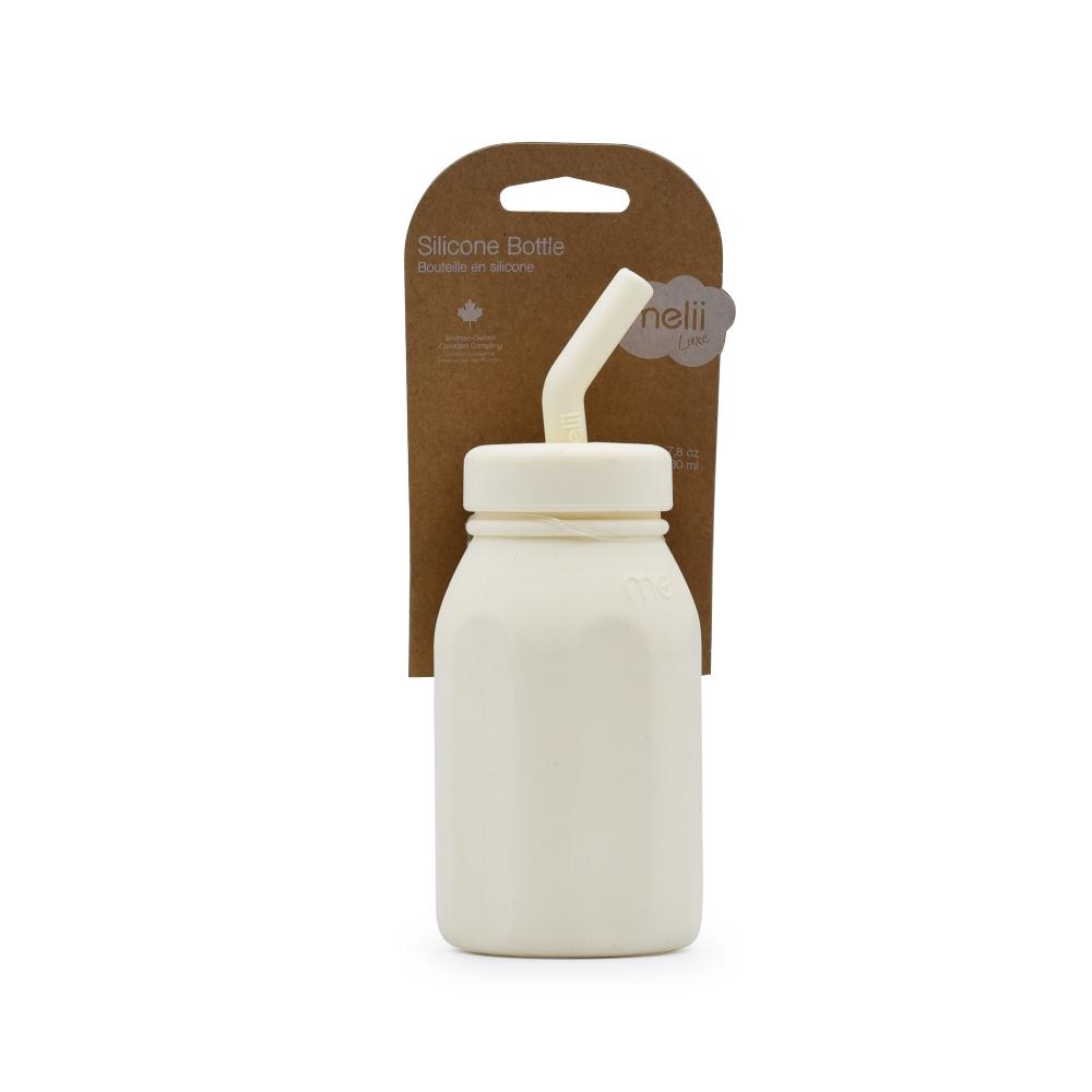 Silicone bottle in ivory colour with straw and packaging on a white background