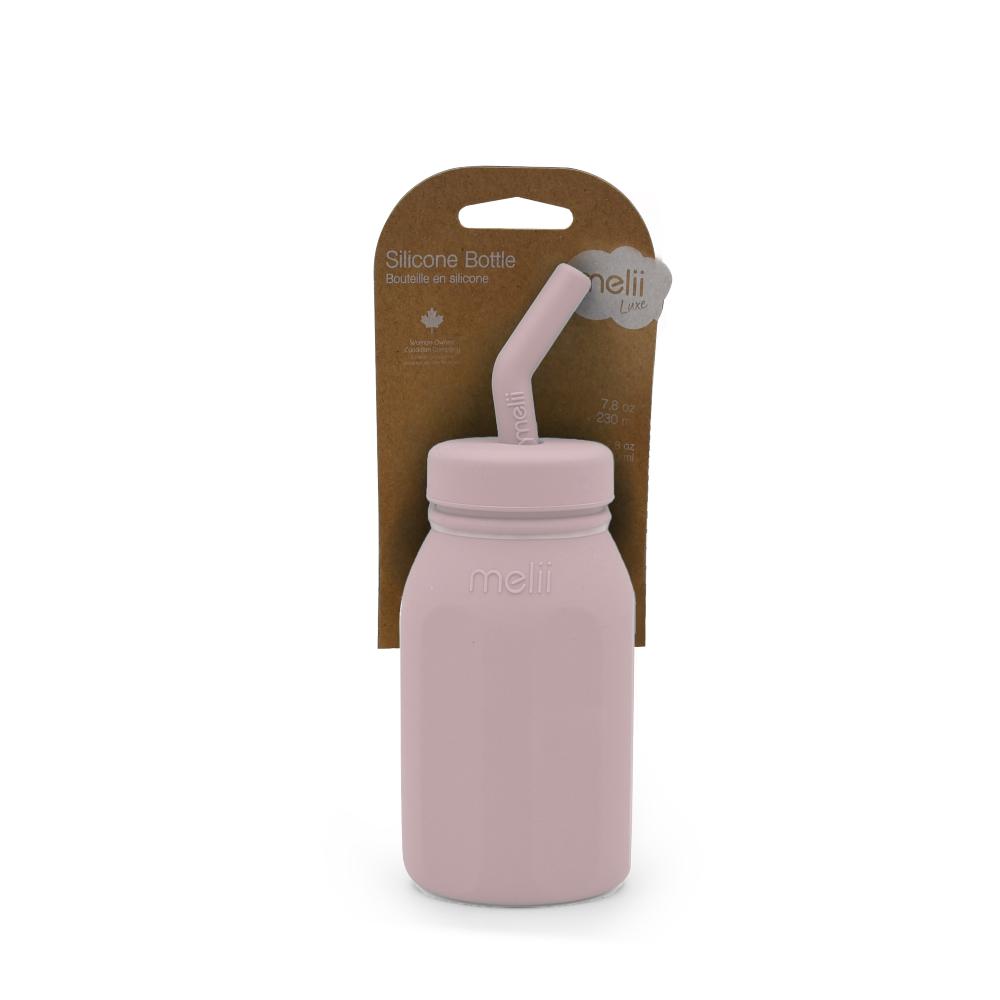Pink silicone bottle with straw and packaging on a white background