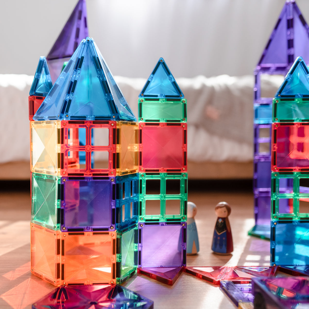 Colorful magnetic building blocks forming a castle on a wooden surface.