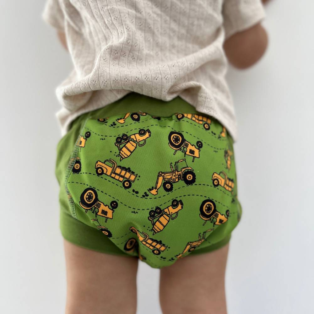 Green training pants with construction vehicle pattern on a white background
