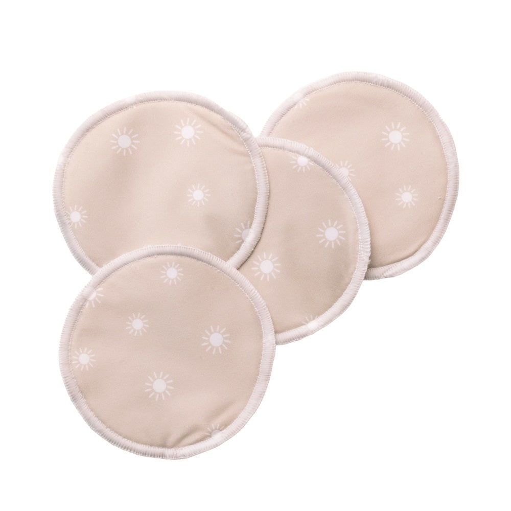 Four beige reusable breast pads with star patterns on a white background