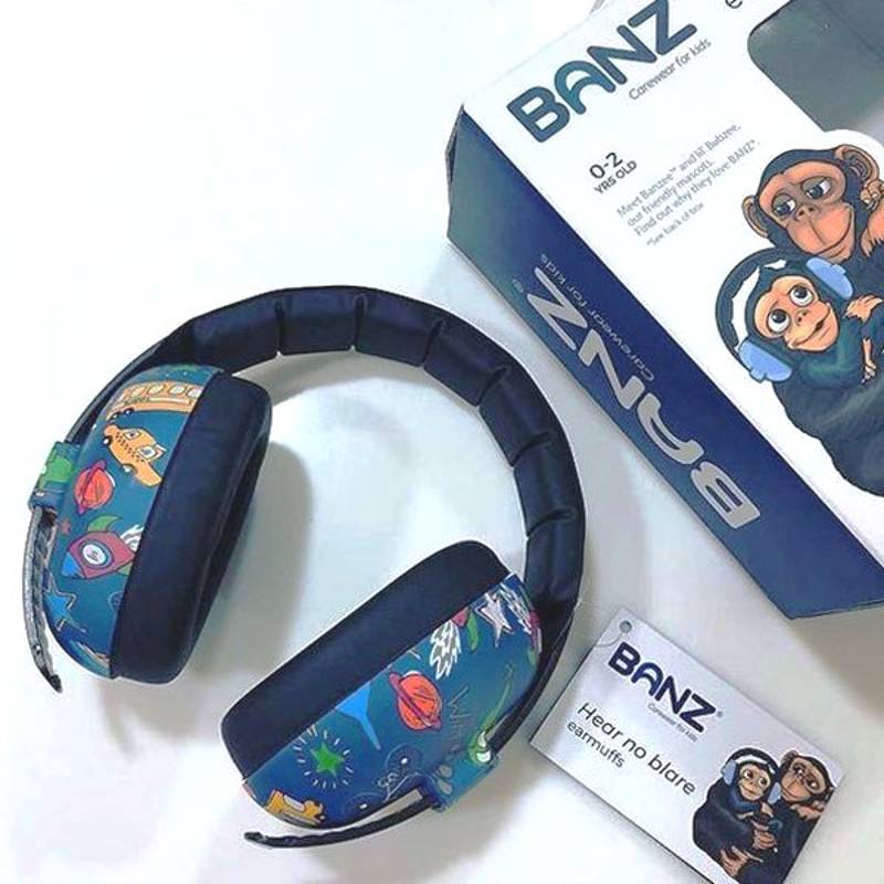 Children's blue ear protection headphones with colorful designs, next to their packaging and a BANZ card on a white background.