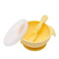 Yellow Silicone Feeding Bowl with lid and silicone spoon on a white background