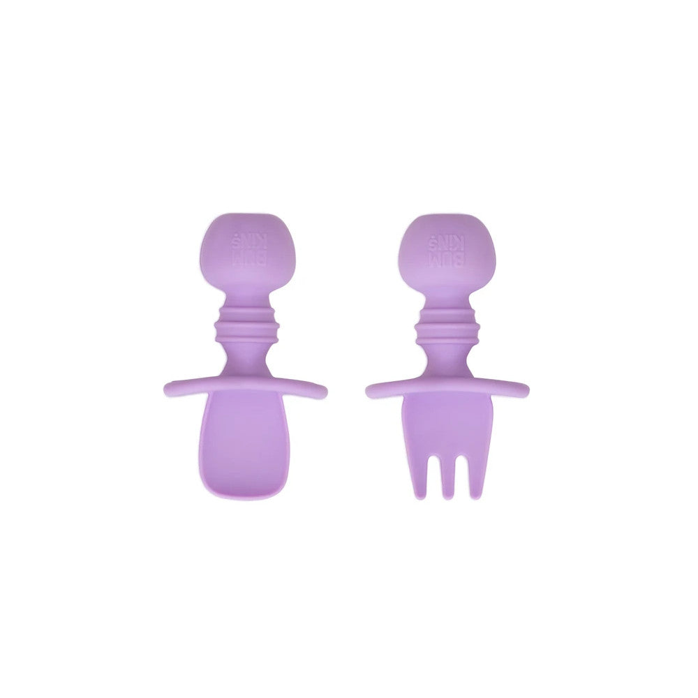 An lavender purple set of silicone baby cutlery chewtensils including one spoon and one fork with bumkins logo on the handle