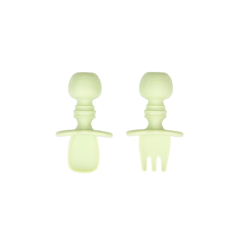 A light sage green set of silicone baby cutlery chewtensils including one spoon and one fork with bumkins logo on the handle