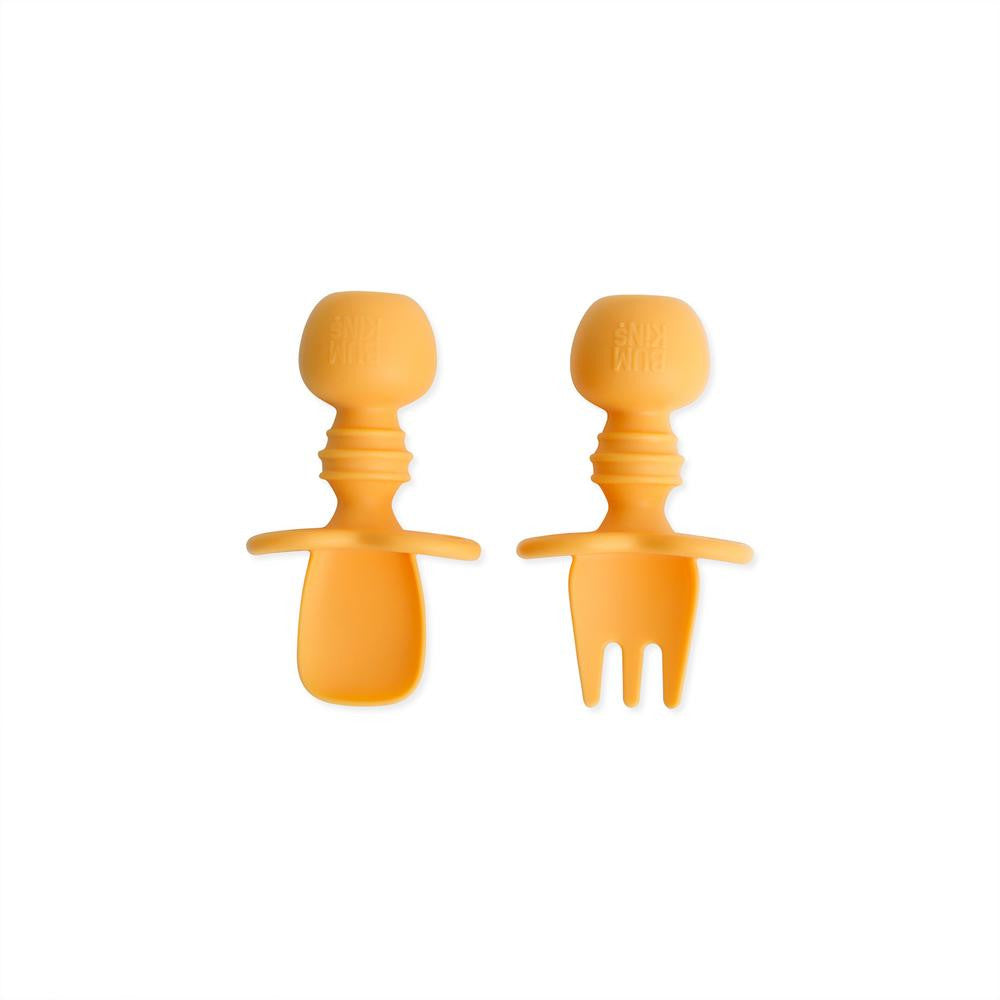 A light orange tangerine set of silicone baby cutlery chewtensils including one spoon and one fork with bumkins logo on the handle