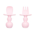 An light pink set of silicone baby cutlery chewtensils including one spoon and one fork with bumkins logo on the handle