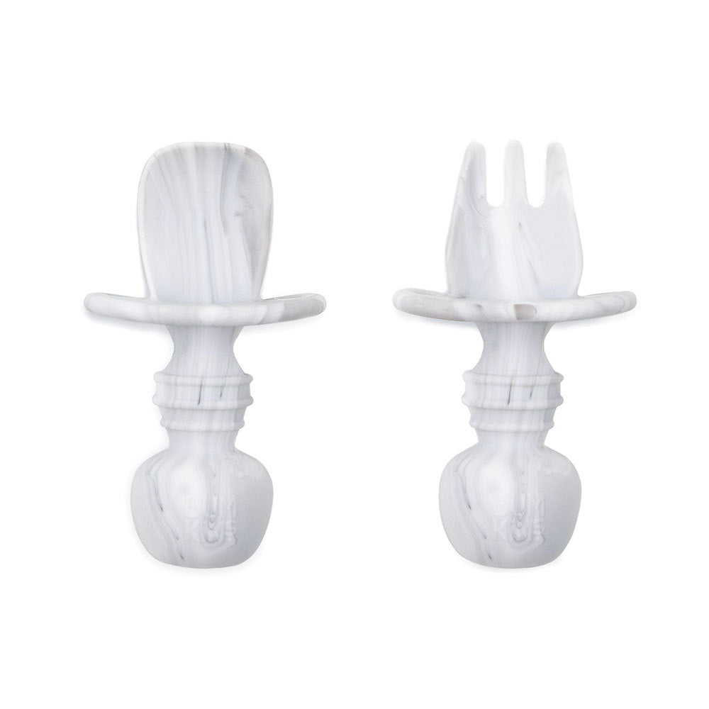 A white and grey marble set of silicone baby cutlery chewtensils including one spoon and one fork with bumkins logo on the handle 