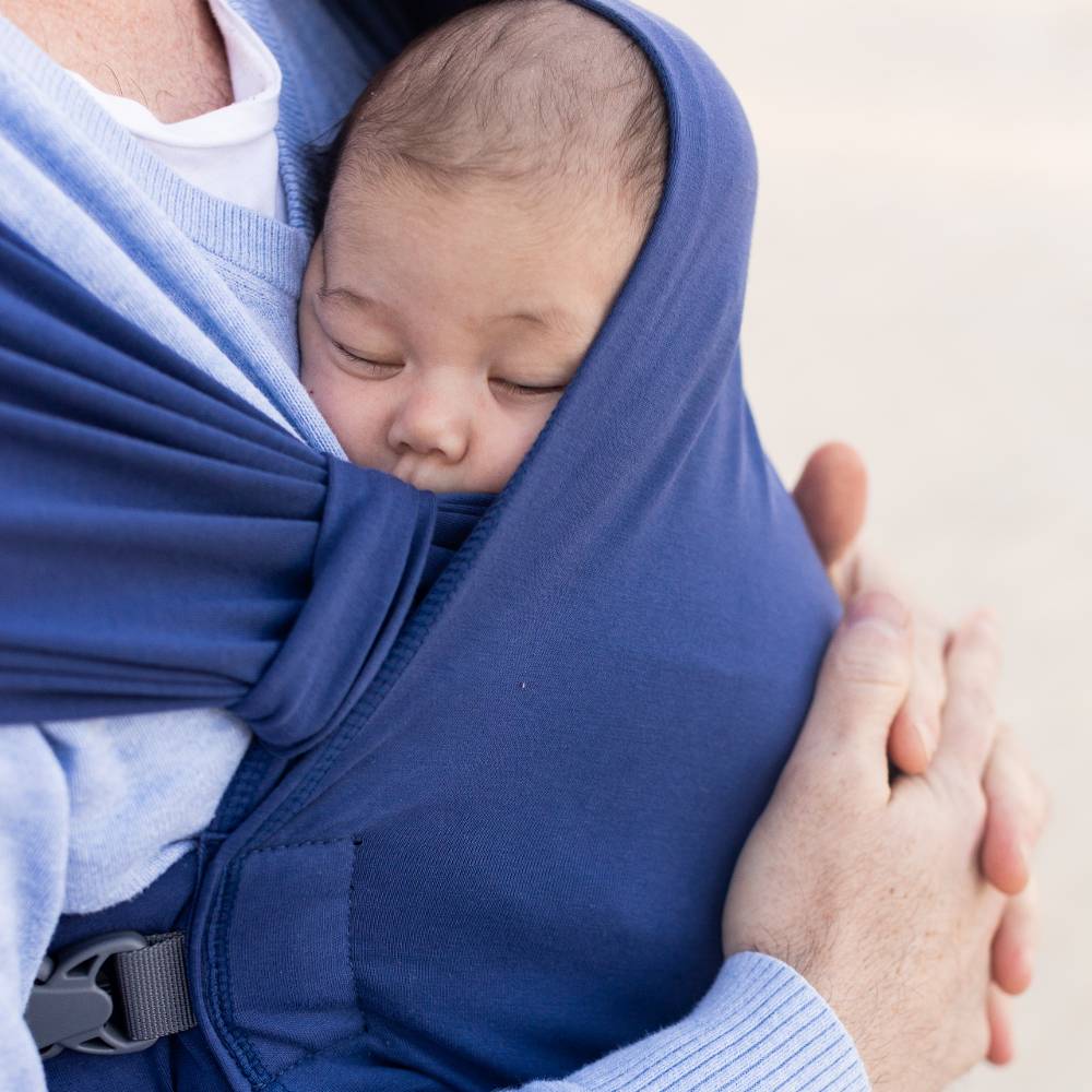 Baby sleeping in a blue Boba Bliss Hybrid wrap carrier