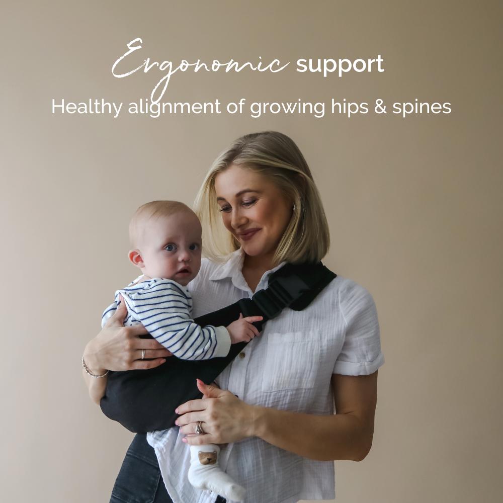 Woman holding a baby in an ergonomic hip carrier with text about support for growing hips and spines.