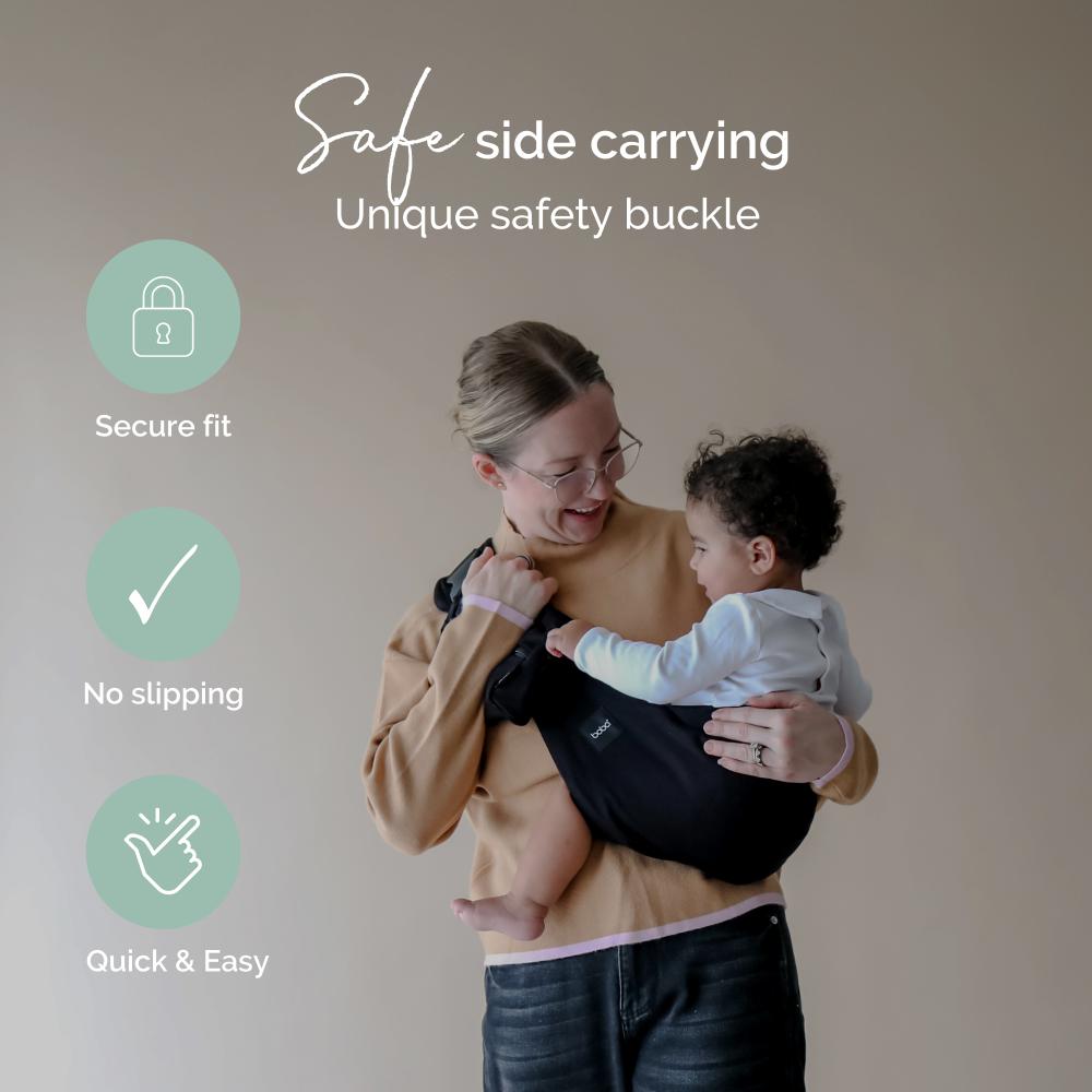 Woman holding a child in a toddler carrier assist with text about safe side carrying and unique safety buckle.